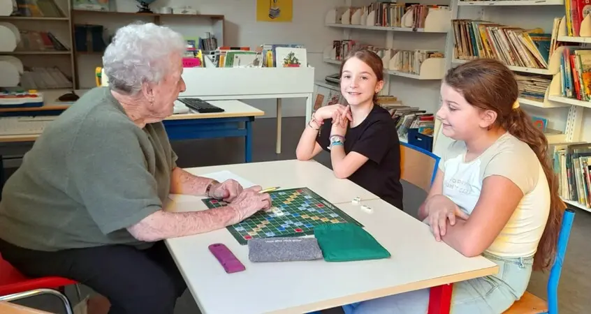 cop-s Session intergénérationnelle de scrabble dans une bibliothèque avec enfants et personne âgée