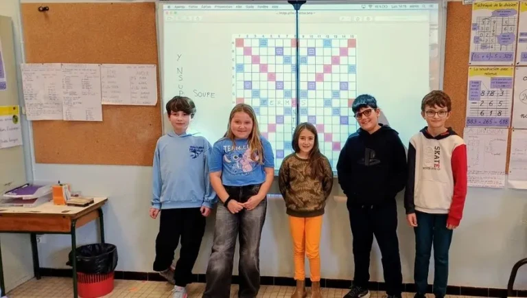 cop-s Enfants souriants devant un tableau de Scrabble en classe