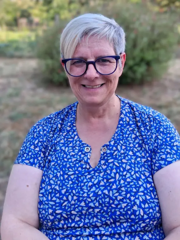 cop-s Femme souriante avec lunettes et cheveux courts dans un jardin