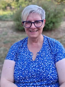 cop-s Femme souriante portant des lunettes et une robe bleue à motifs